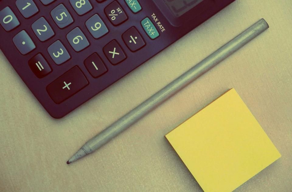 Calculadora e post-it sobre a mesa